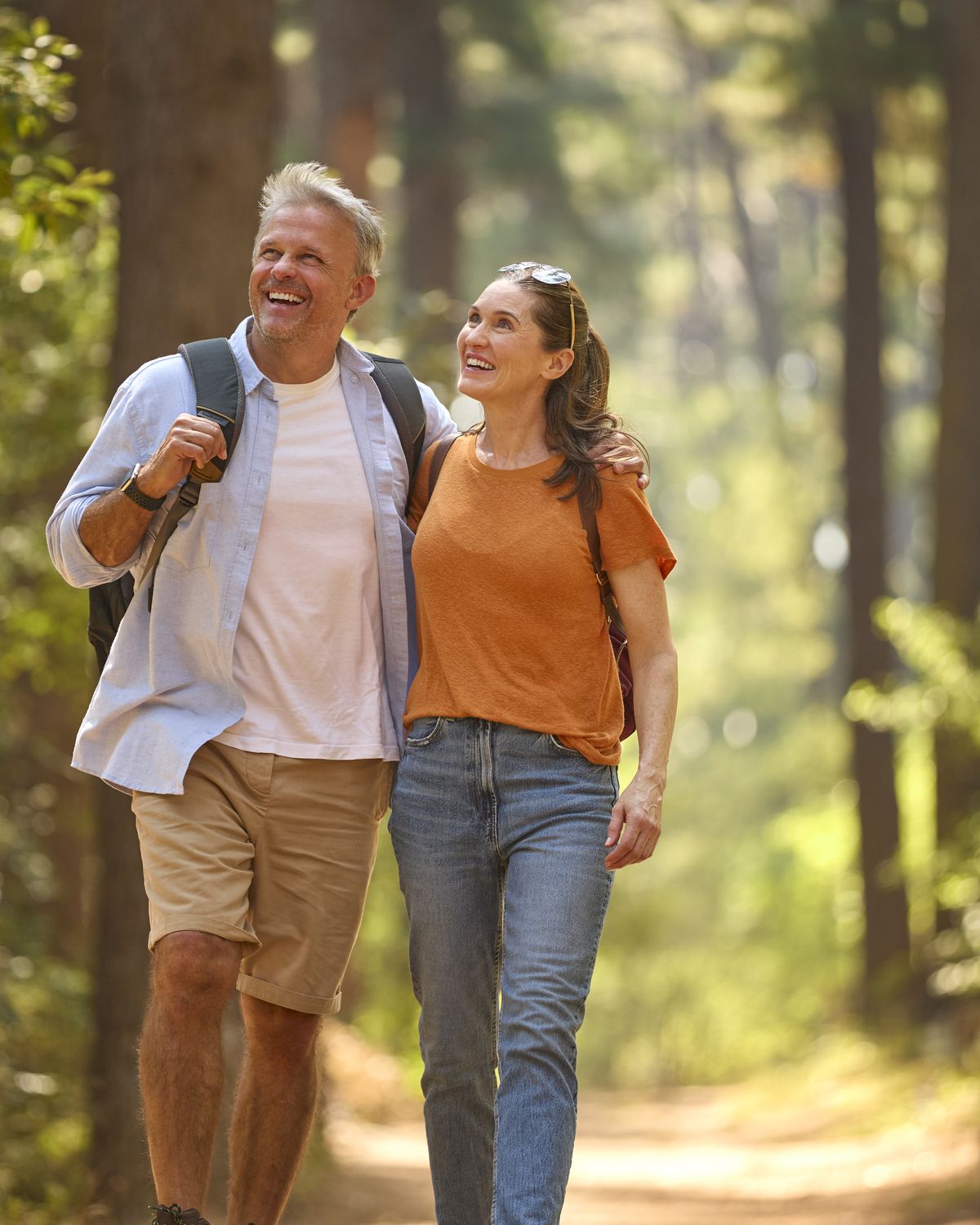 Smiling couple walking together on a wooded hiking trail